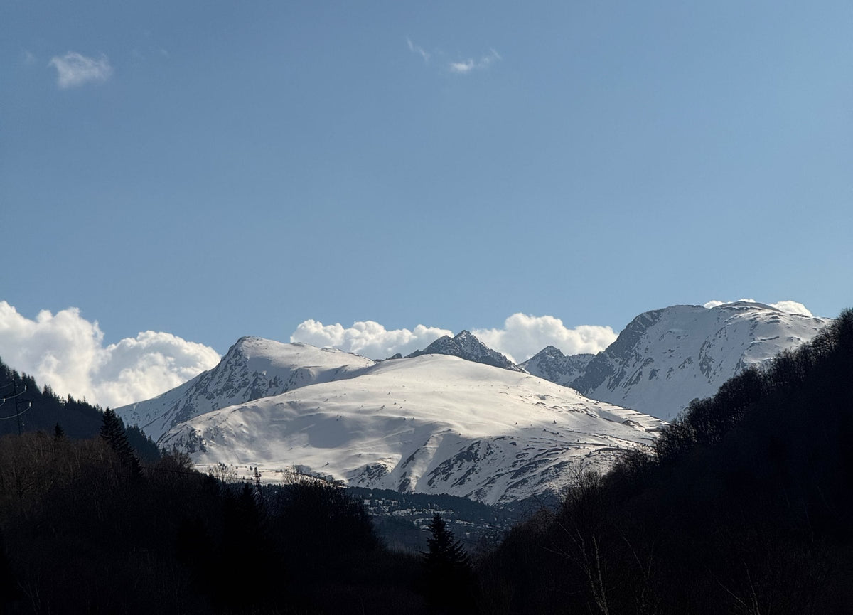 Snow-covered Pyrenean peaks above a wooded valley, seen from the N20 near Mérens-les-Vals