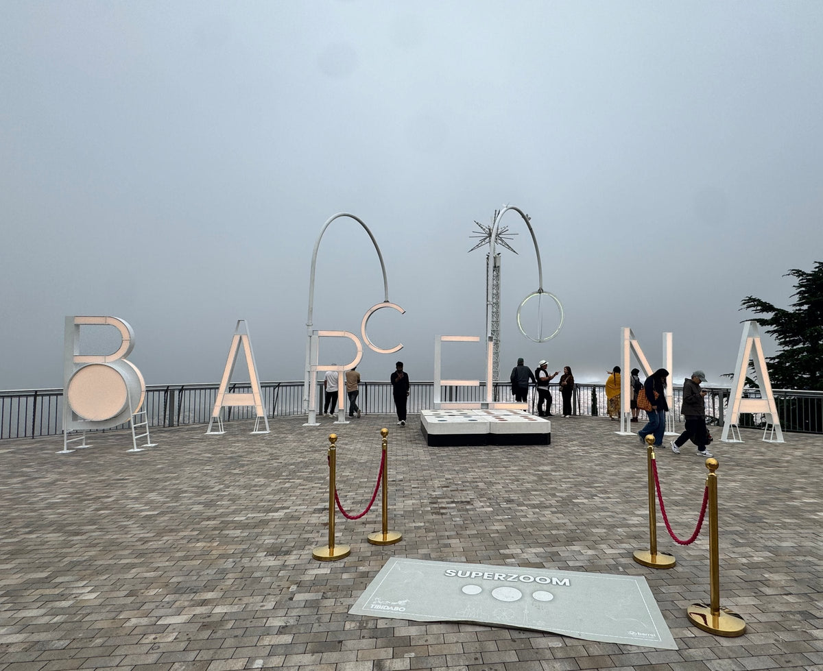 The giant white BARCELONA letters on Tibidabo's terrace, with the city lost in fog