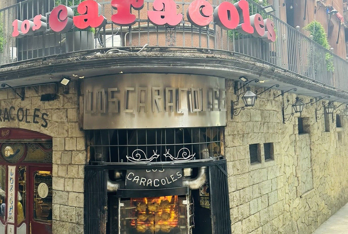 The corner of Los Caracoles on Carrer dels Escudellers, with its sign and rotisserie window