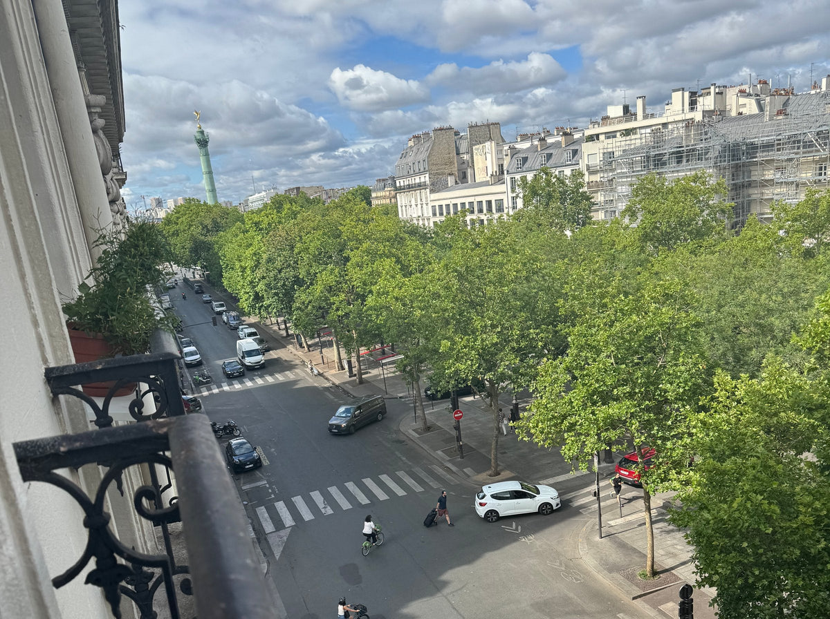 The view from the balcony over the plane trees of Boulevard Richard-Lenoir, with the July Column in the distance