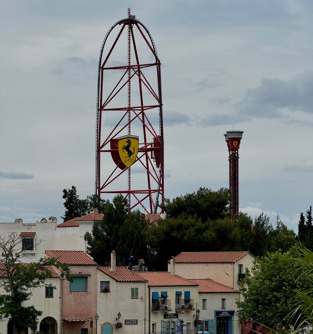 The Red Force coaster tower with the Ferrari shield, rising behind the houses of Mediterrània at PortAventura